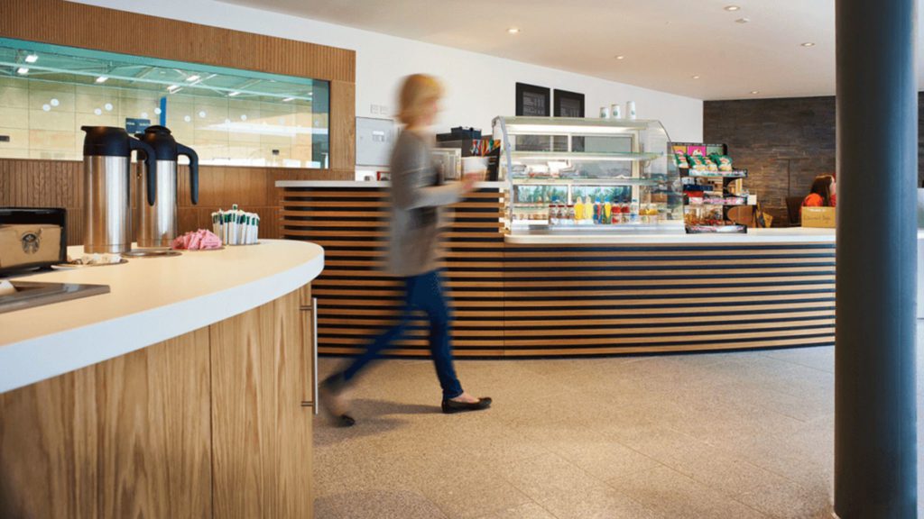 A student walking through the cafe facility in the Sports Centre